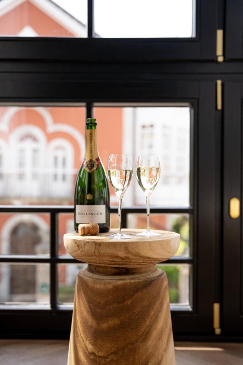 Una botella de vino y dos copas en una mesa en Hotel Boutique Las Indianas, en Nueva de Llanes