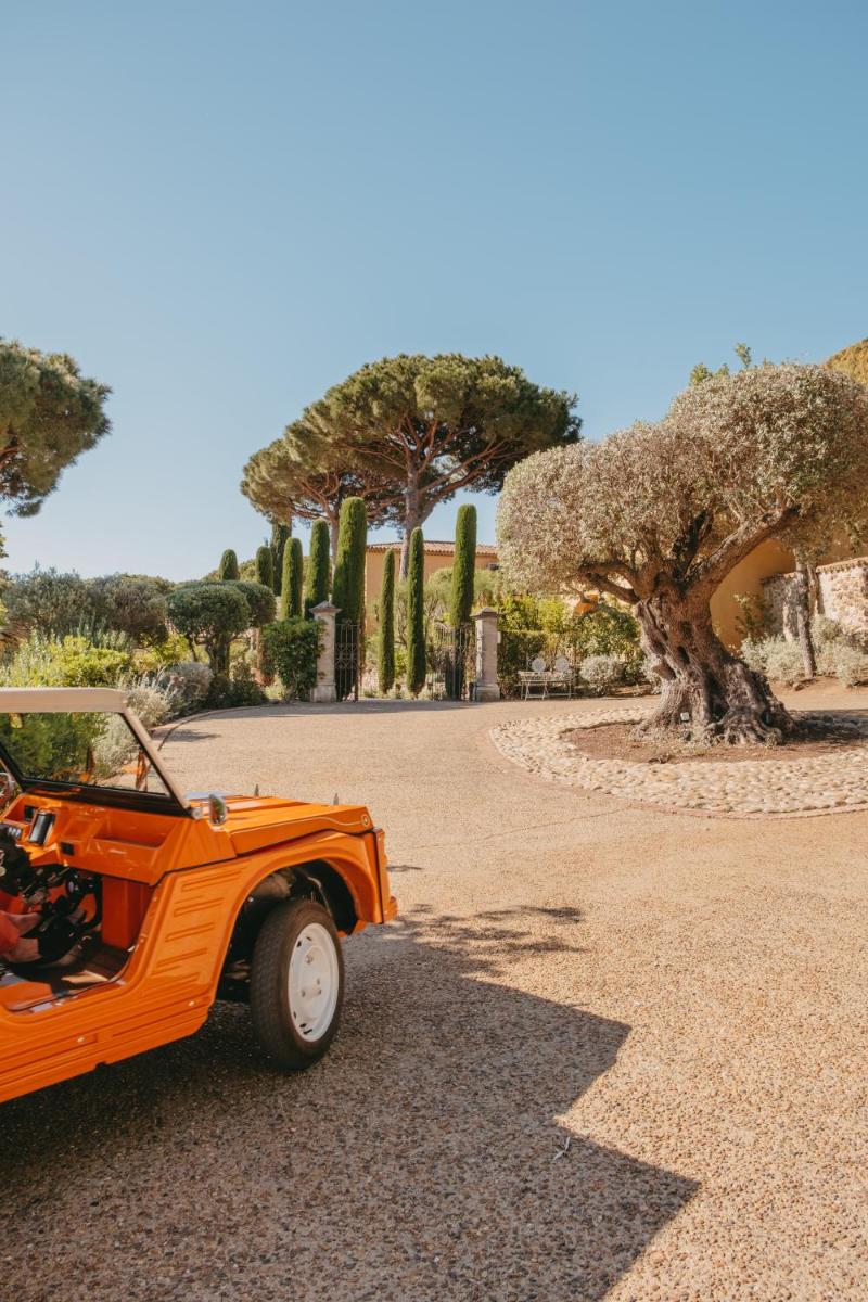 une voiture orange garée dans une allée avec des arbres dans l'établissement Hôtel Villa Marie Saint Tropez, à Saint-Tropez