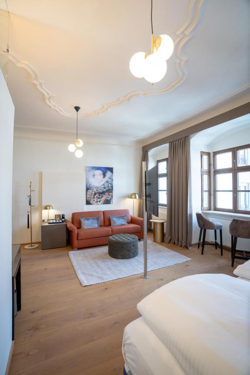 ein Schlafzimmer mit Bett und ein Wohnzimmer in der Unterkunft Maxim Suites by Elias Holl in Augsburg