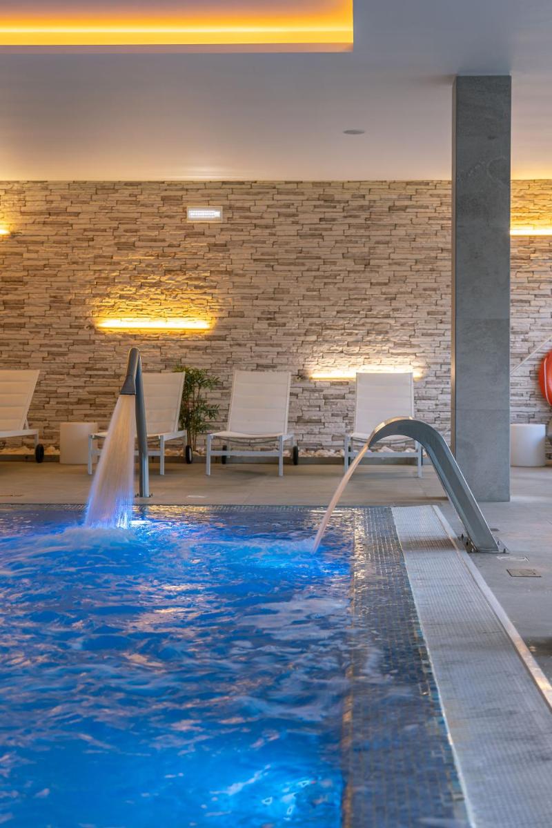 uma piscina com uma fonte de água num edifício em Pena Park Hotel em Ribeira de Pena