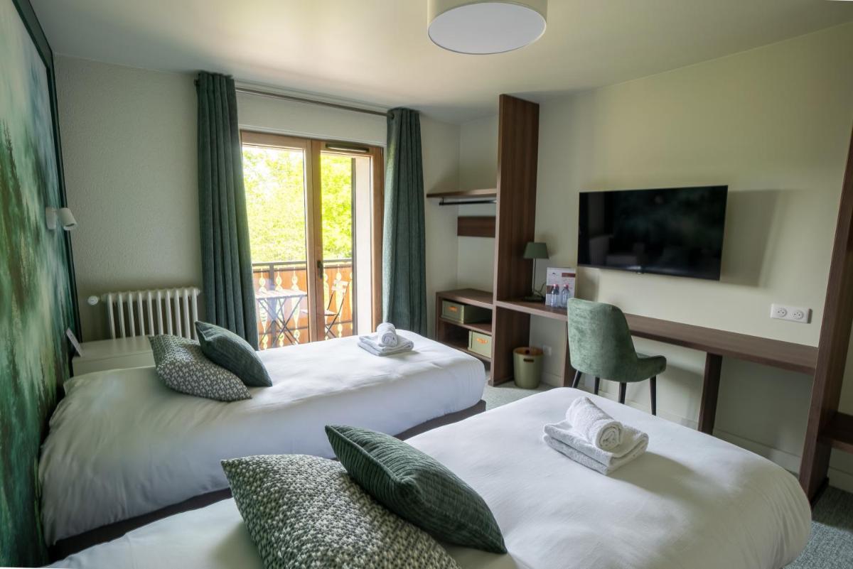 une chambre d'hôtel avec deux lits et une télévision dans l'établissement Hotel Le Bois Joli, à Bernex 70 autres photos
