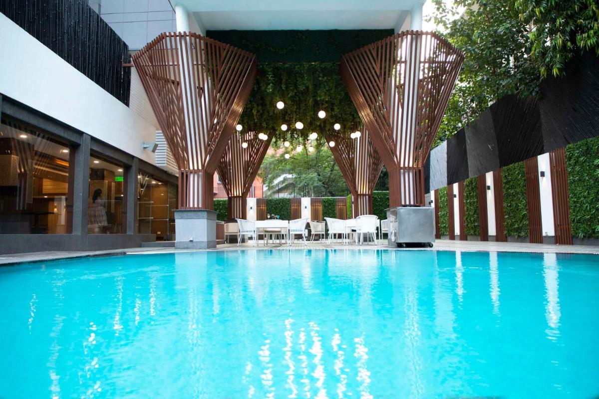 a large swimming pool with tables and chairs in a building at Park Inn by Radisson,South Delhi in New Delhi a large swimming pool with tables and chairs in a building at Park Inn by Radisson,South Delhi in New Delhi