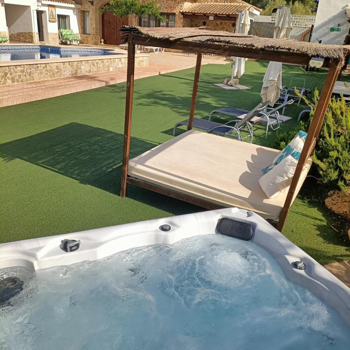 Una bañera de hidromasaje en un patio trasero con una cama. en Artmonia, en Castalla