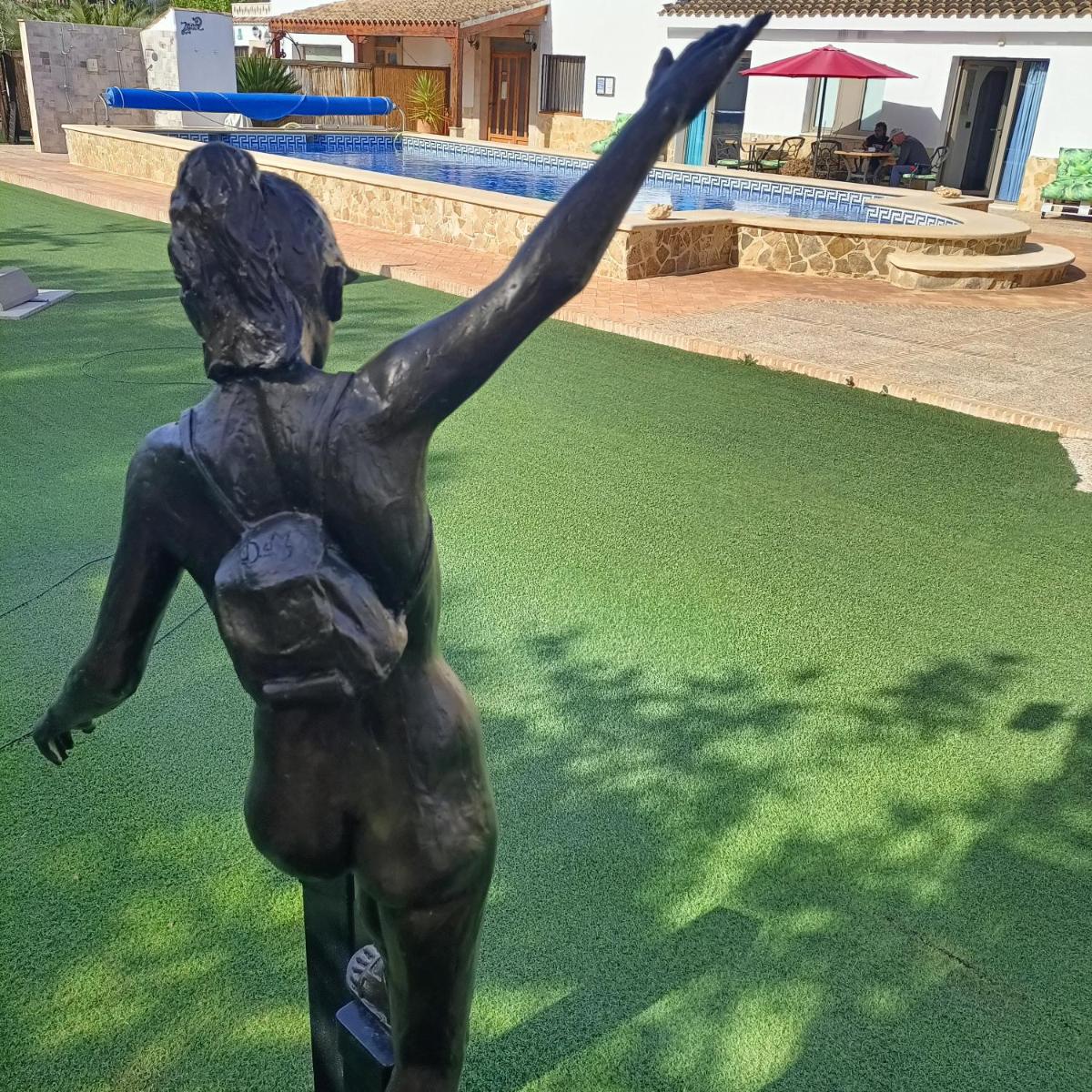 Una estatua de una mujer que se eleva hacia el aire. en Artmonia, en Castalla