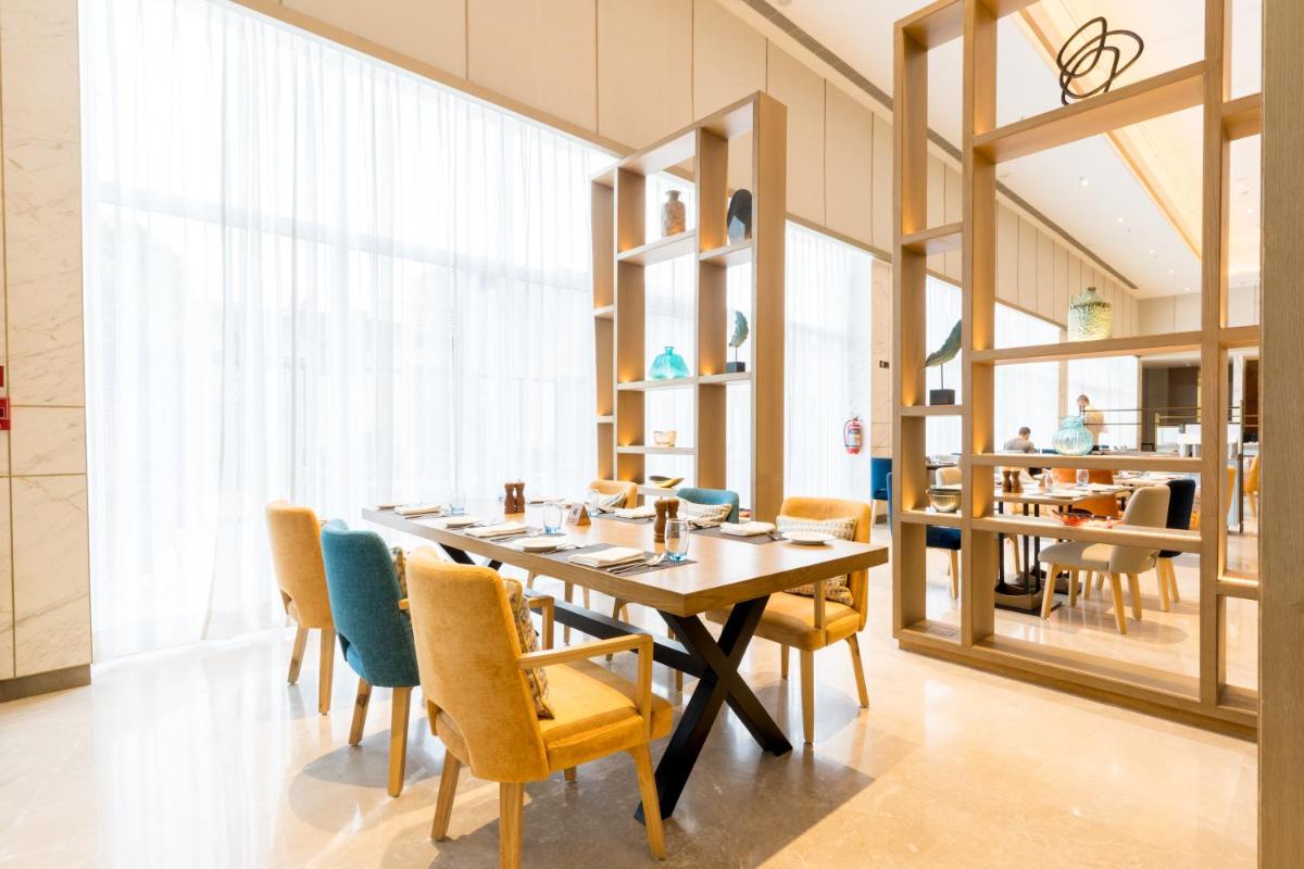a dining room with a long table and chairs at Holiday Inn Lucknow Airport by IHG in Lucknow