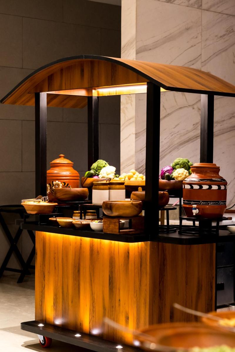 a buffet of food on a table with different foods at Holiday Inn Lucknow Airport by IHG in Lucknow