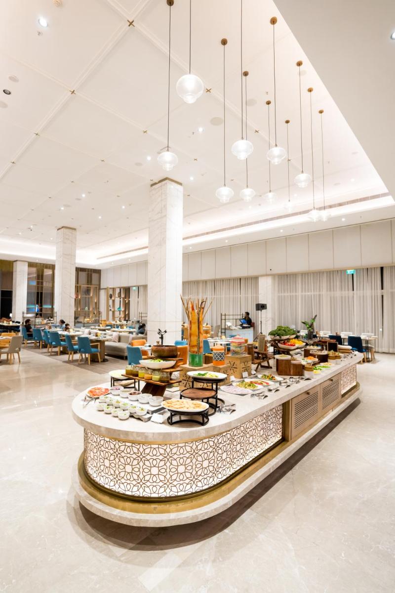 a large lobby with a table with food on it at Holiday Inn Lucknow Airport by IHG in Lucknow