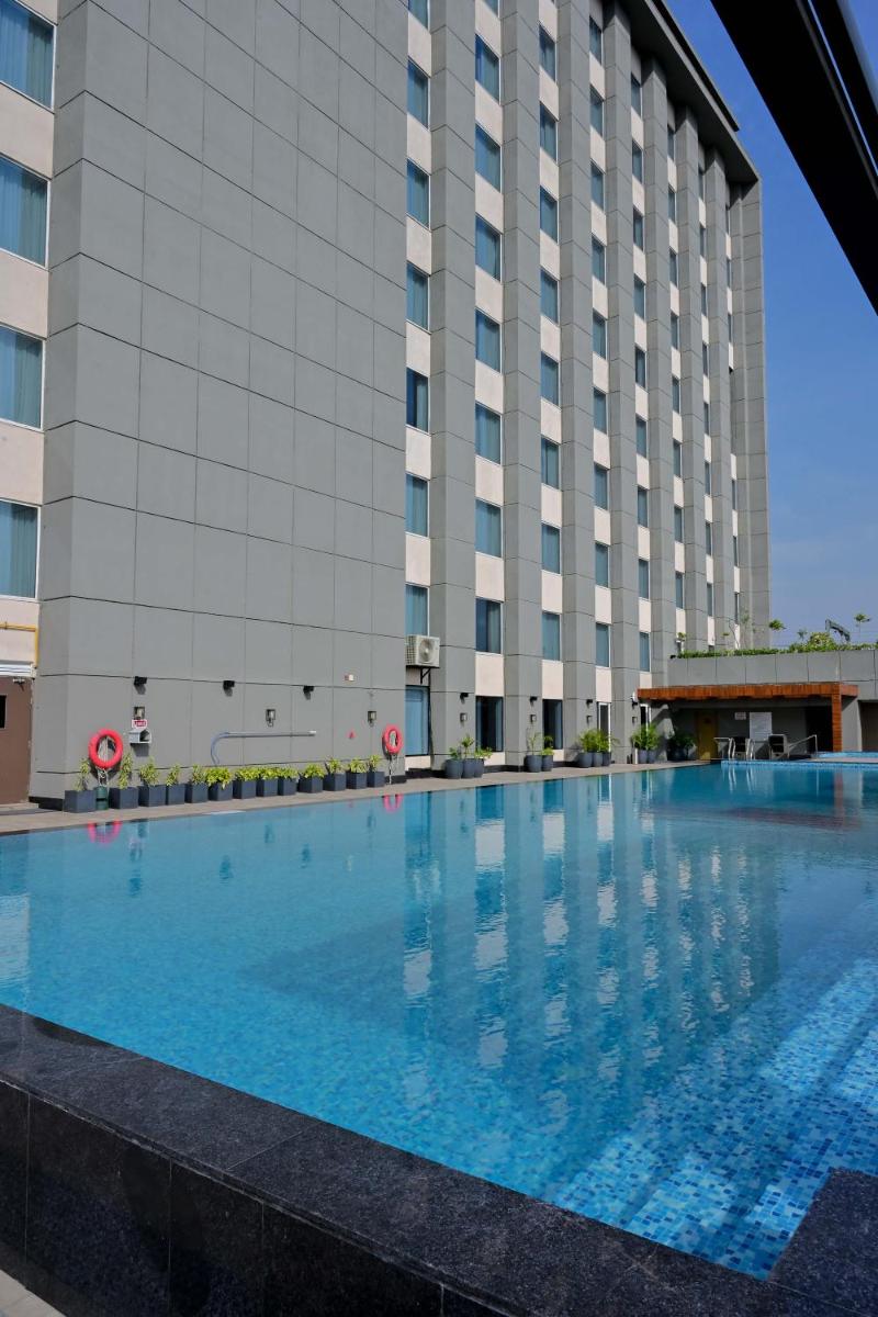 a large swimming pool in front of a building at Holiday Inn Lucknow Airport by IHG in Lucknow