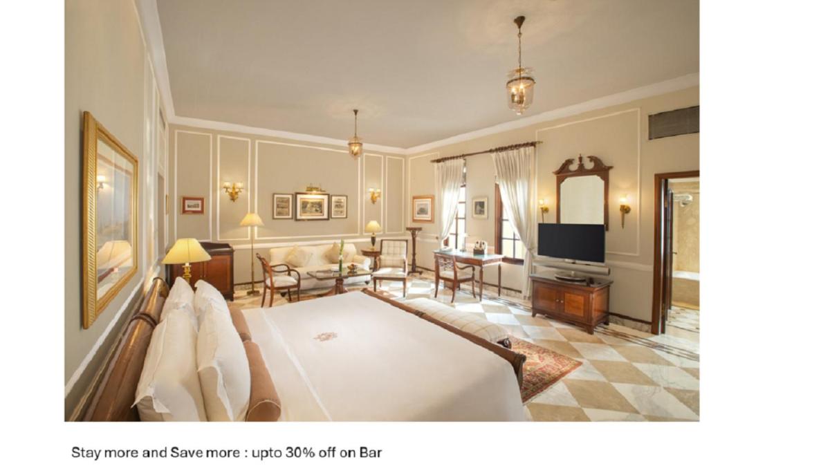 a bedroom with a large bed and a living room at The Imperial, New Delhi in New Delhi a bedroom with a large bed and a living room at The Imperial, New Delhi in New Delhi