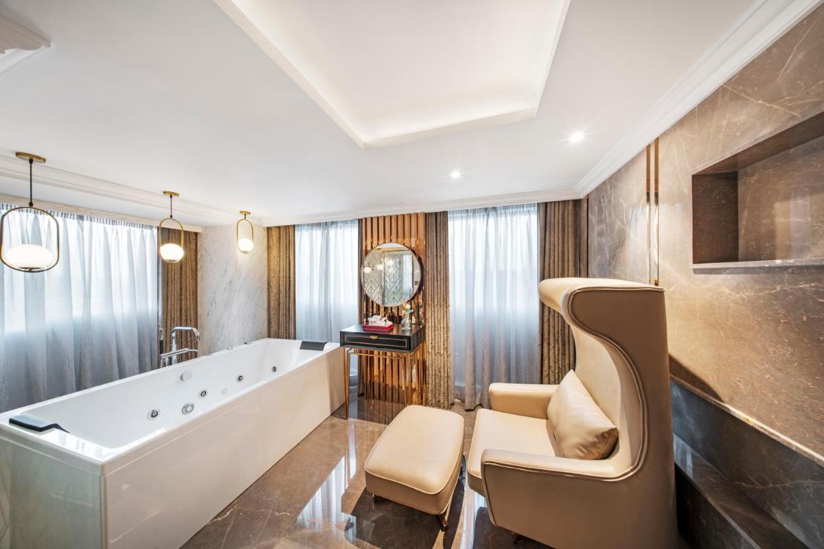 a bathroom with a large tub and a chair at Radisson Blu Hotel & Suites GRT Chennai in Chennai