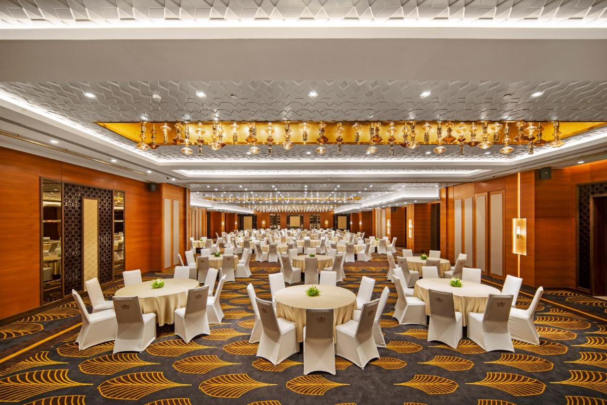 a banquet hall with white tables and white chairs at Radisson Blu Hotel & Suites GRT Chennai in Chennai