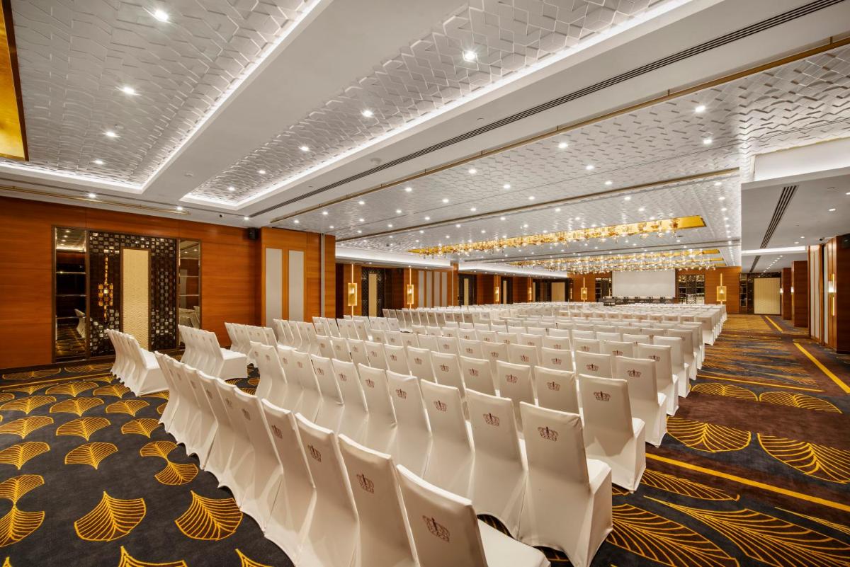 a banquet hall with white chairs in a room at Radisson Blu Hotel & Suites GRT Chennai in Chennai