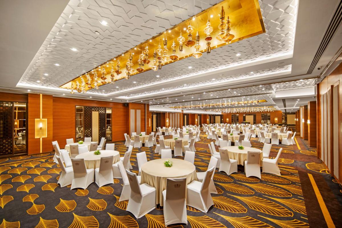 a banquet hall with white tables and white chairs at Radisson Blu Hotel & Suites GRT Chennai in Chennai