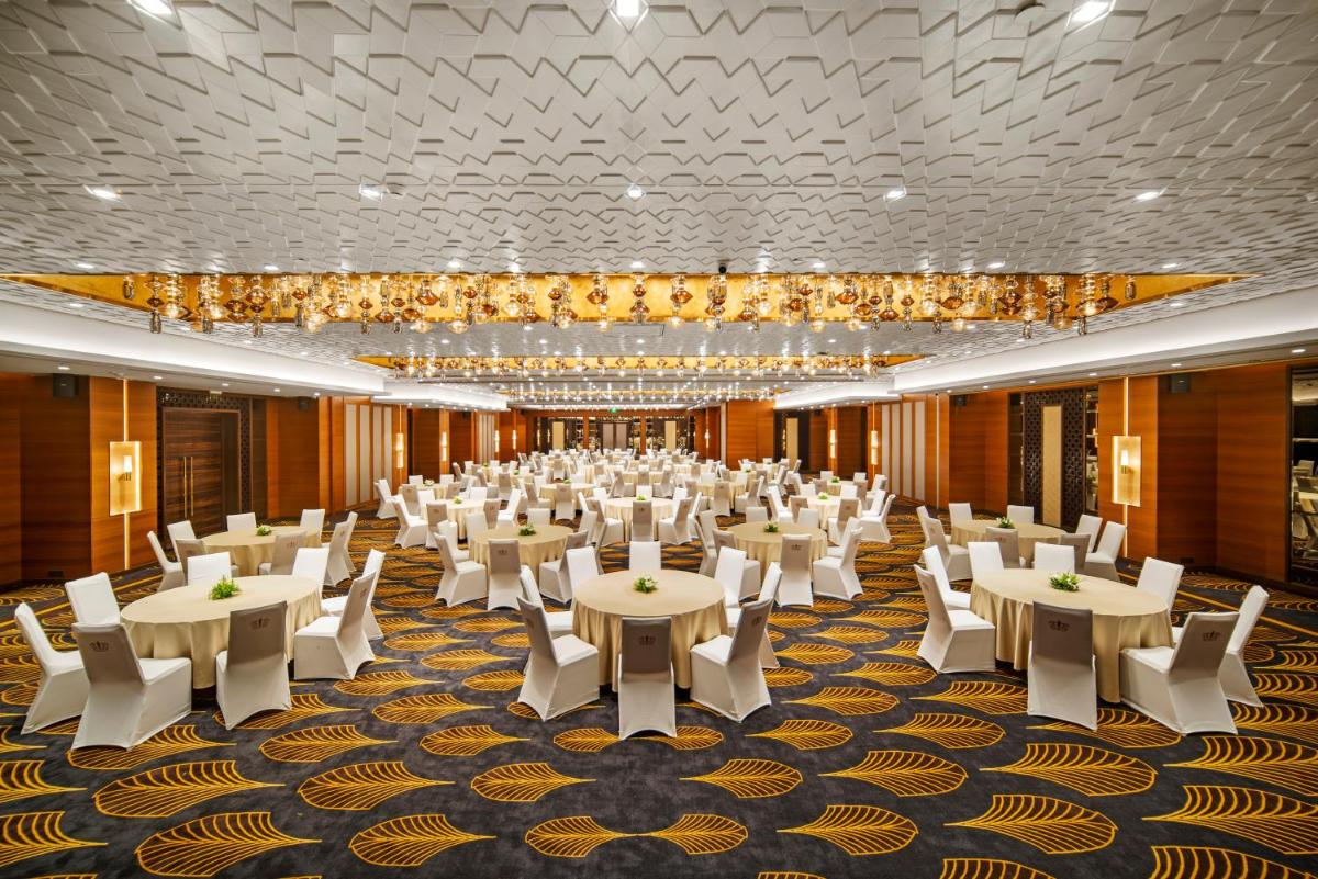 a banquet hall with white tables and white chairs at Radisson Blu Hotel & Suites GRT Chennai in Chennai