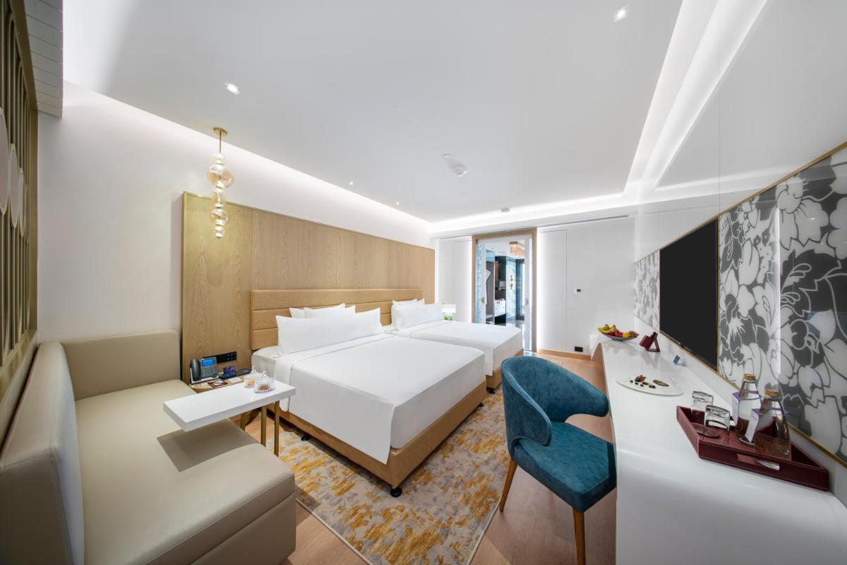 a hotel room with a bed and a desk at Radisson Blu Hotel & Suites GRT Chennai in Chennai