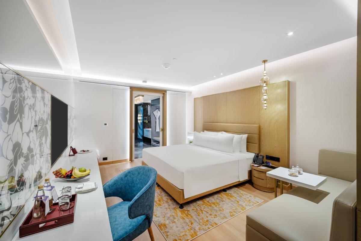 a hotel room with a bed and a living room at Radisson Blu Hotel & Suites GRT Chennai in Chennai