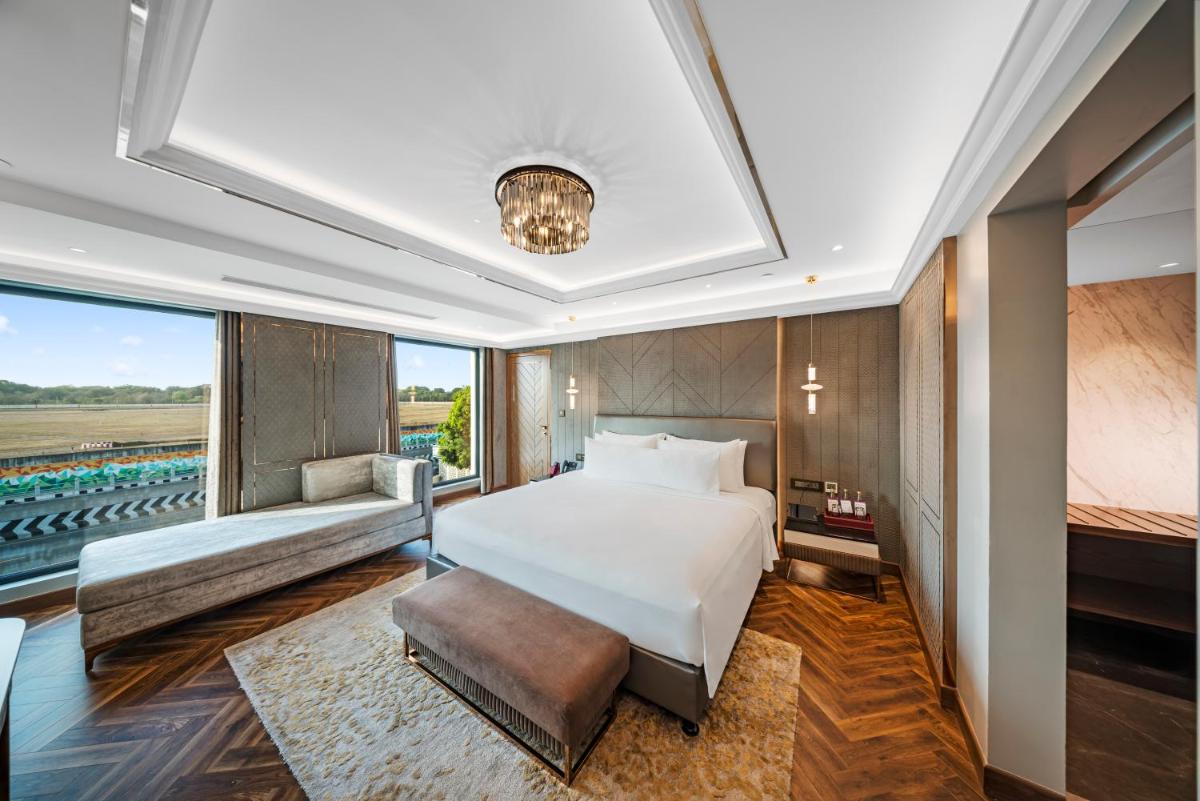 a bedroom with a bed and a large window at Radisson Blu Hotel & Suites GRT Chennai in Chennai