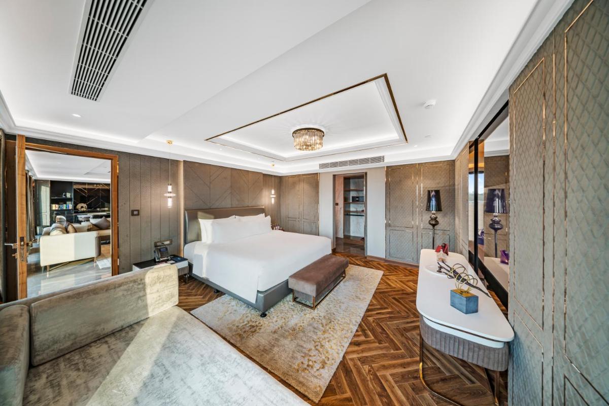 a hotel room with a bed and a couch at Radisson Blu Hotel & Suites GRT Chennai in Chennai
