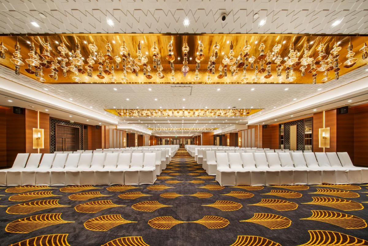 a conference room with white chairs and a chandelier at Radisson Blu Hotel & Suites GRT Chennai in Chennai