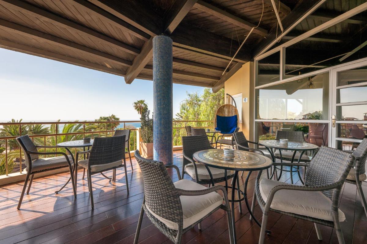 un patio con mesas y sillas en una terraza en Hotel LIVVO Risco del Gato Suites, en Costa Calma