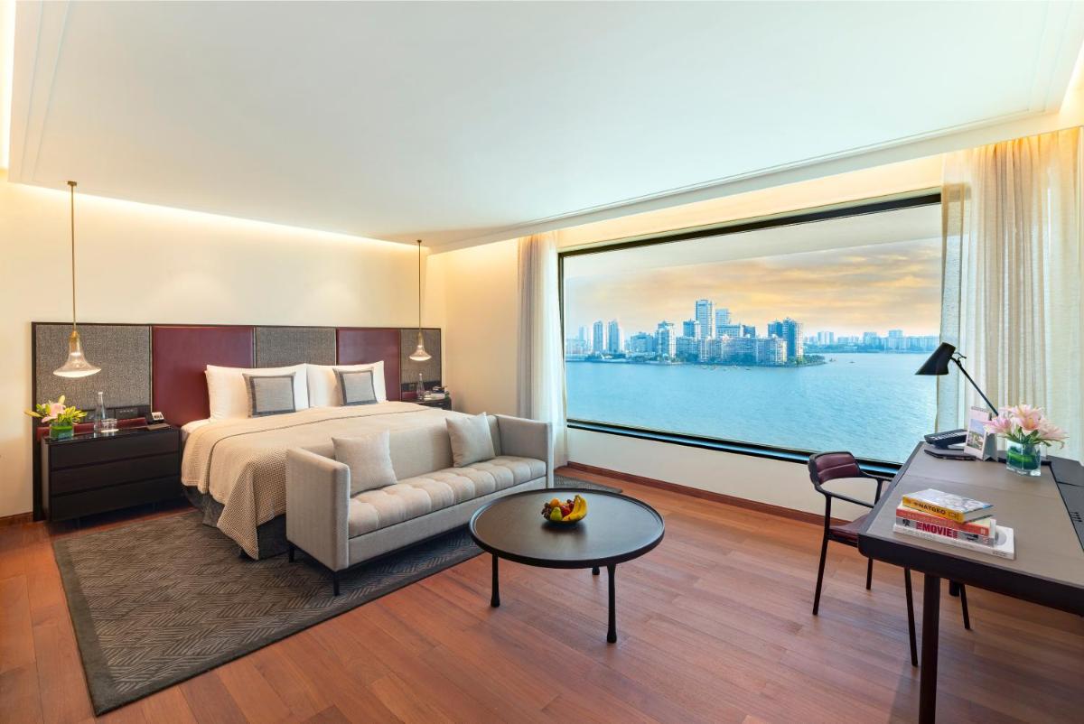 a hotel room with a bed and a large window at The Oberoi Mumbai in Mumbai