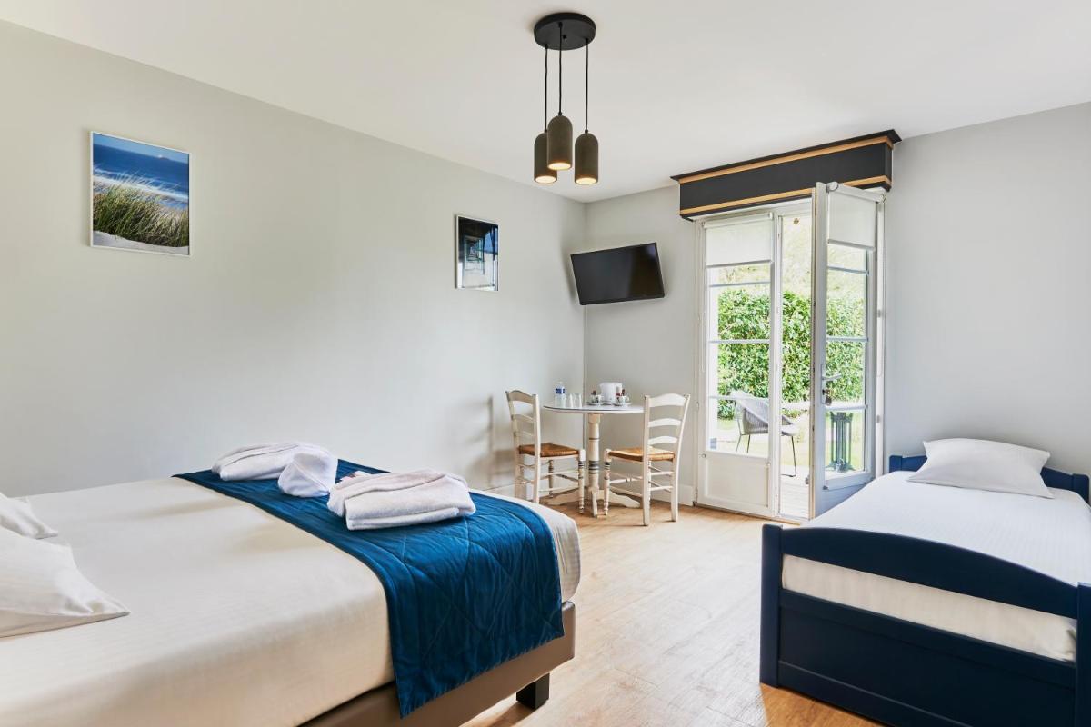 - une chambre avec 2 lits et une table avec une chaise dans l'établissement Hotel Spa Les Saules, à Favières