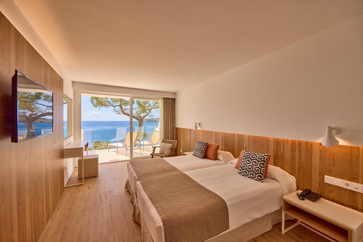 Un dormitorio con una cama grande con vista al mar. en Aparthotel Ponent Mar, en Palmanova