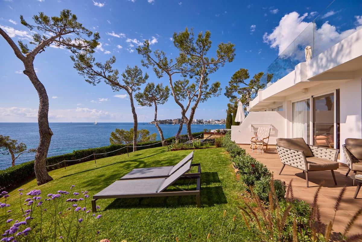un patio con un banco y vistas al océano en Aparthotel Ponent Mar, en Palmanova