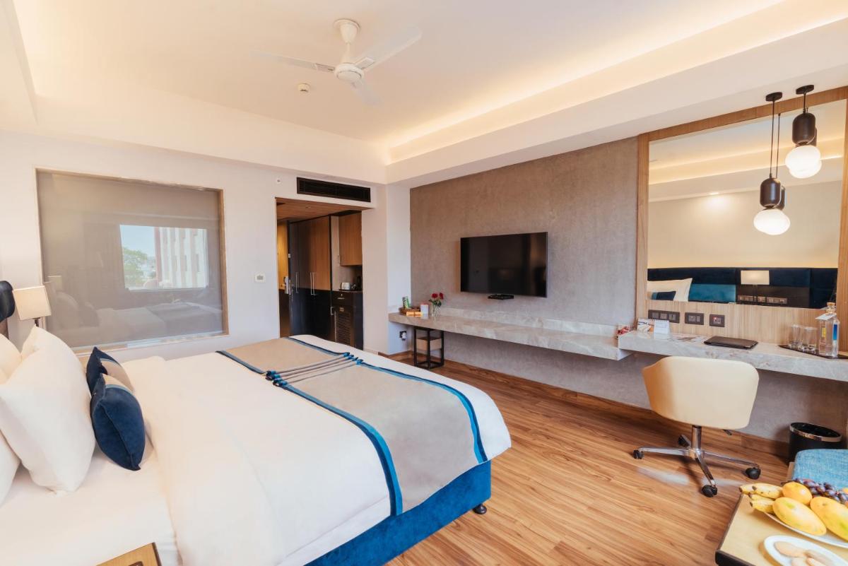 a hotel room with a bed and a television at The Piccadily in Lucknow