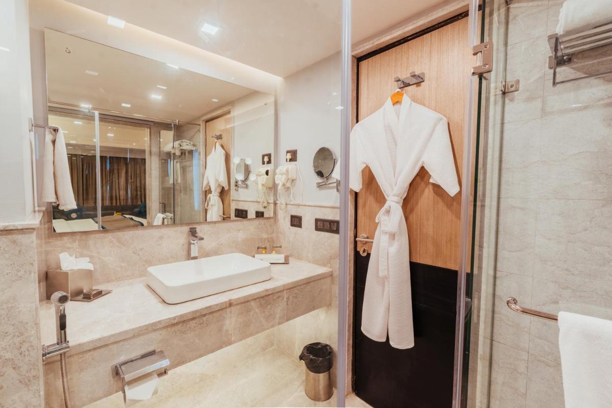 a bathroom with a sink and a mirror at The Piccadily in Lucknow