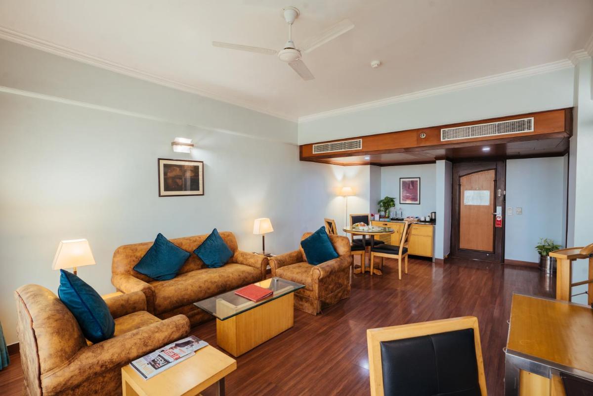 a living room with a couch and a table at The Piccadily in Lucknow