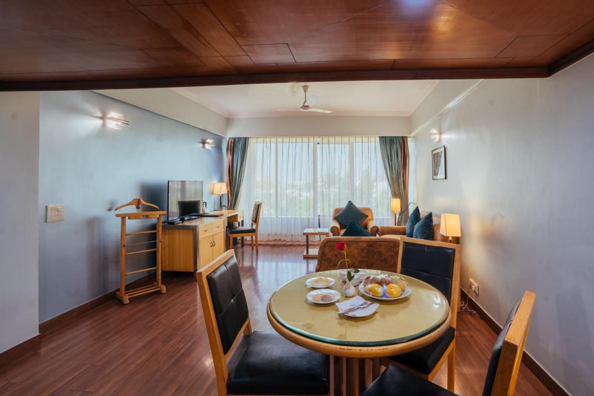 a living room with a table and a dining room at The Piccadily in Lucknow