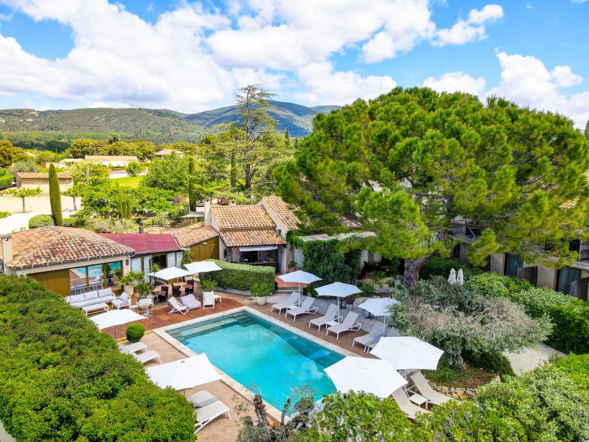 - une vue aérienne sur une maison avec une piscine et des chaises dans l'établissement Hotel Bastide & SPA - Villa de Lourmarin, à Lourmarin