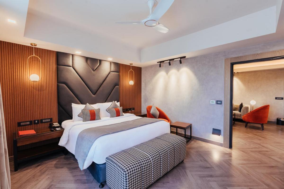 a hotel room with a large bed and a chair at The Piccadily in Lucknow