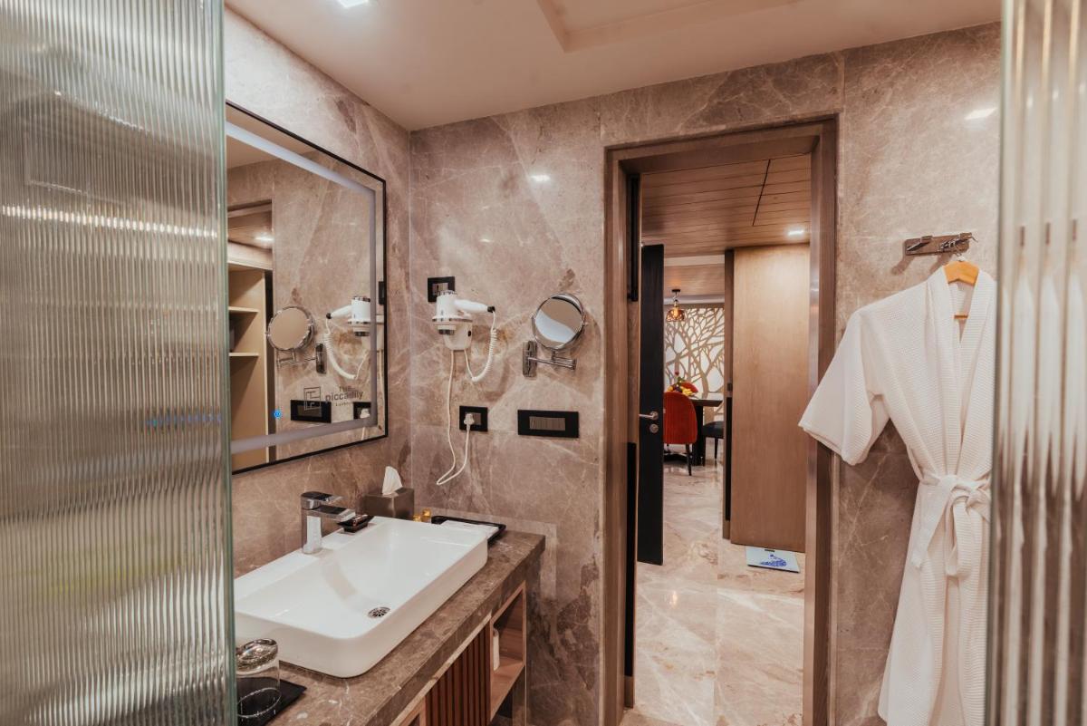 a bathroom with a sink and a mirror at The Piccadily in Lucknow