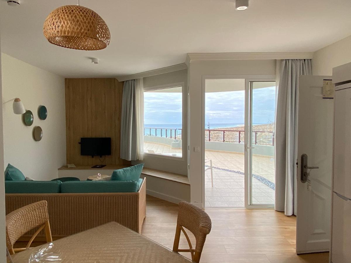 Una sala de estar con un sofá y vista al mar. en Hotel Esmeralda Maris by LIVVO, en Costa Calma