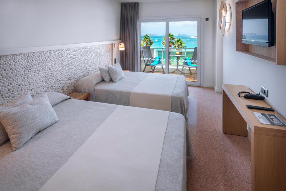 Una habitación de hotel con dos camas y vista al mar. en Caprici Beach Hotel & Spa, en Santa Susanna