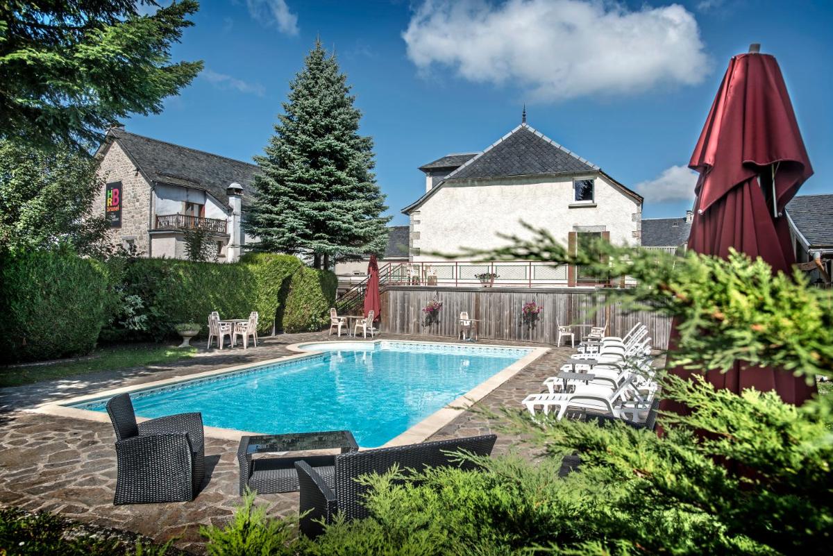 une piscine avec des chaises et une maison dans l'établissement Hotel Le Rocher Blanc, à Albaret-Sainte-Marie