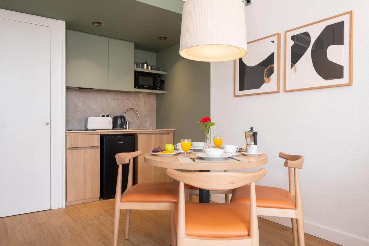 Una cocina y un comedor con mesa y sillas. en Aparthotel Duva & Spa, en Puerto Pollensa