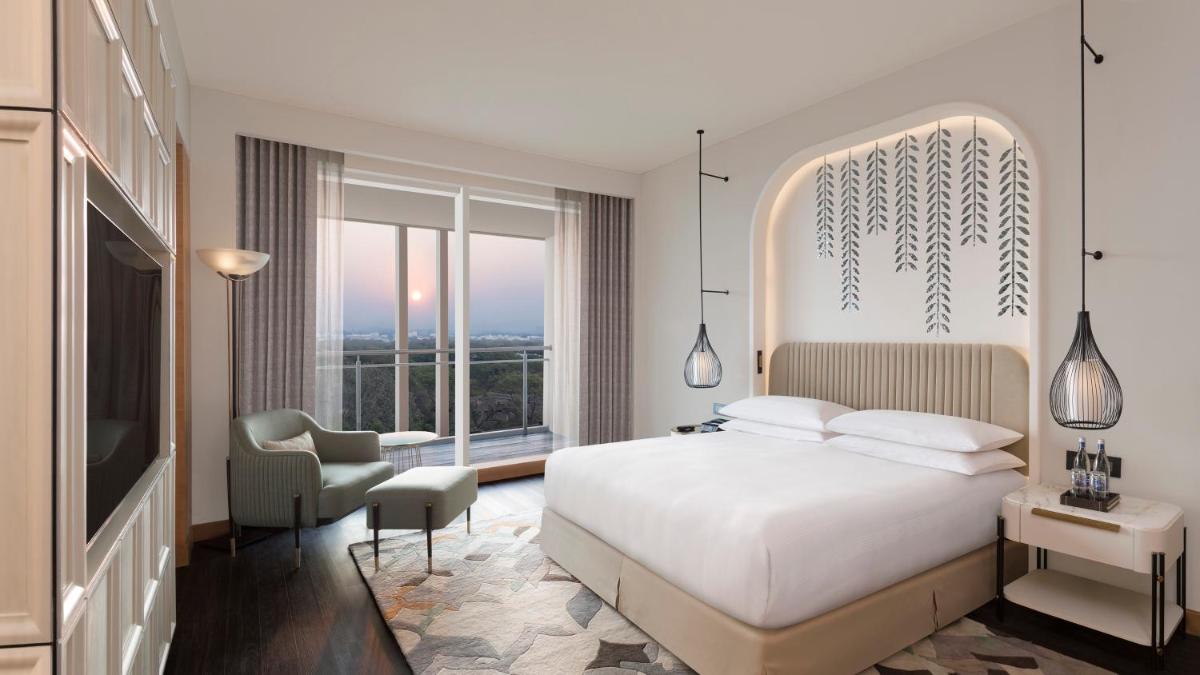 a bedroom with a white bed and a large window at InterContinental Jaipur Tonk Road by IHG in Jaipur