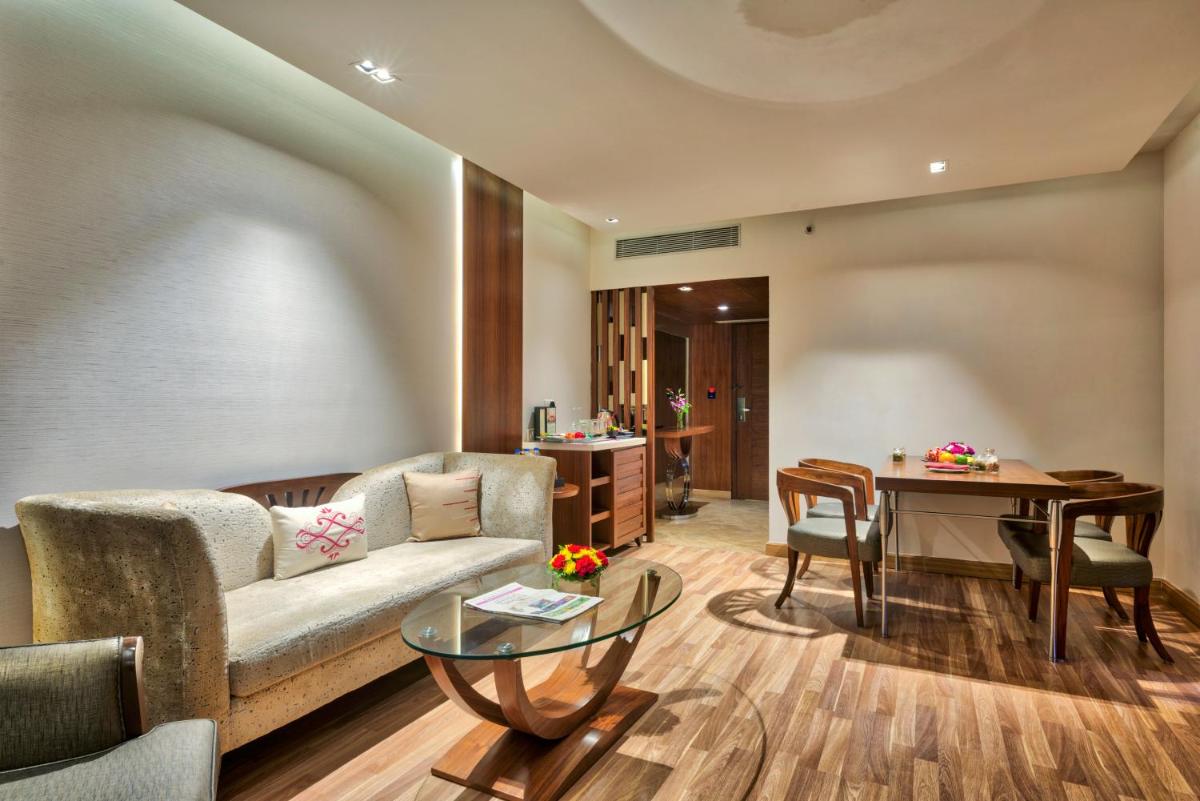 a living room with a couch and a table at Grand Chennai by GRT Hotels in Chennai