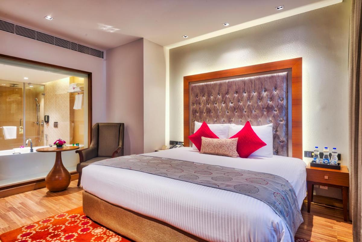 a hotel room with a bed and a bath tub at Grand Chennai by GRT Hotels in Chennai