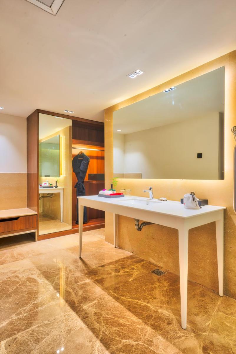 a bathroom with a sink and a large mirror at Grand Chennai by GRT Hotels in Chennai