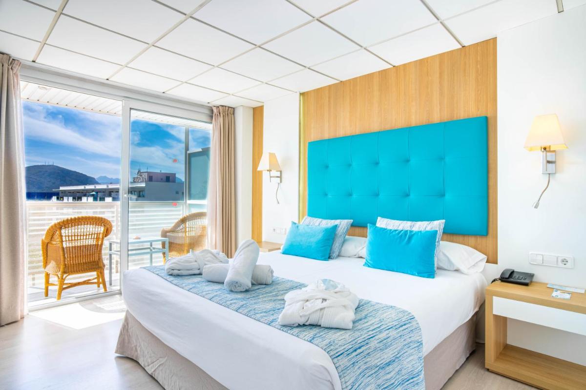 Una habitación de hotel con dos camas y balcón. en Bahía de Alcudia Hotel & Spa, en Puerto de Alcudia