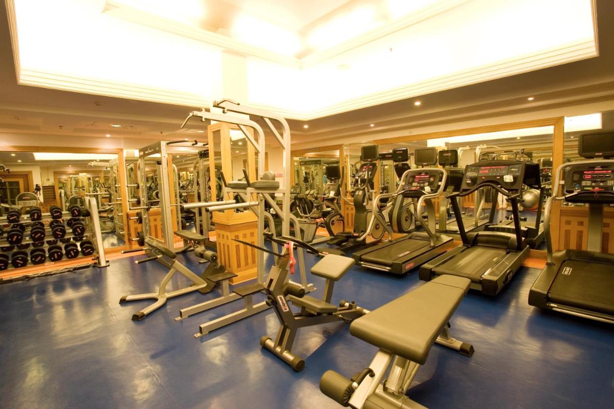 a gym with lots of treadmills and machines at Grand Chennai by GRT Hotels in Chennai