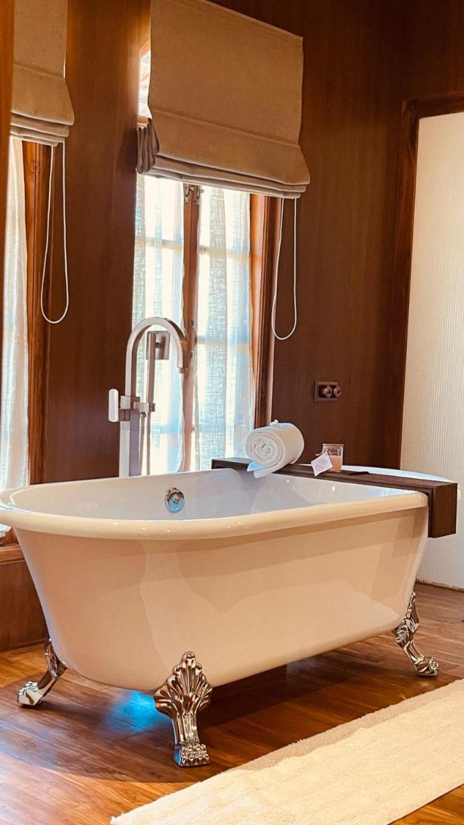 a white bath tub with a sink in a room at The Postcard Saligao in Calangute