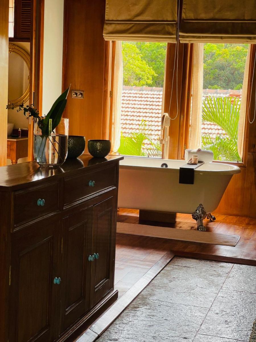 a bath tub in a bathroom with a window at The Postcard Saligao in Calangute