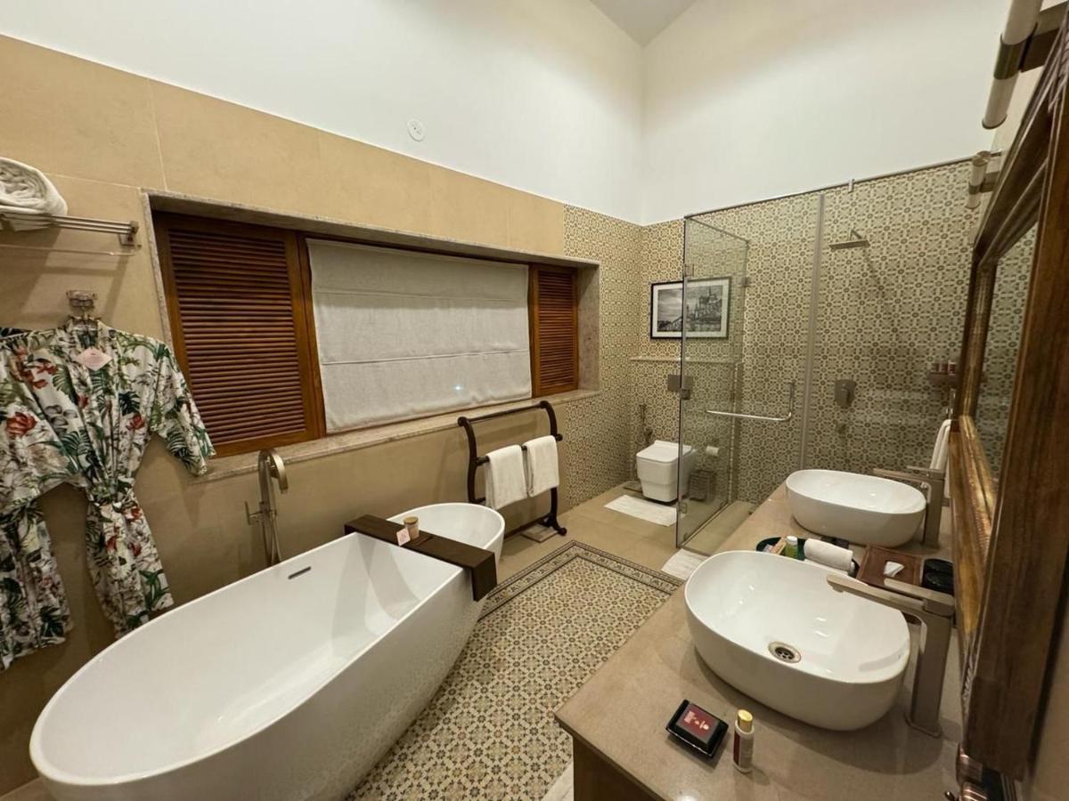 a bathroom with a tub and a toilet and a sink at The Postcard Saligao in Calangute