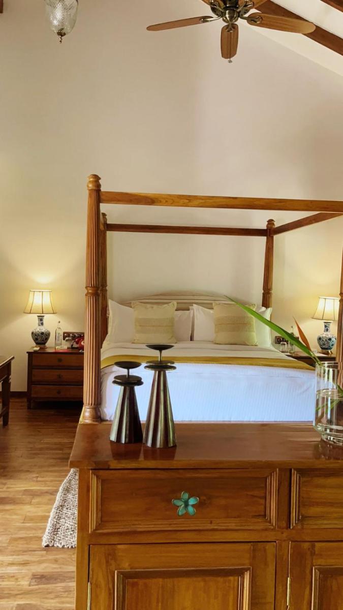 a bedroom with a large bed with a wooden frame at The Postcard Saligao in Calangute