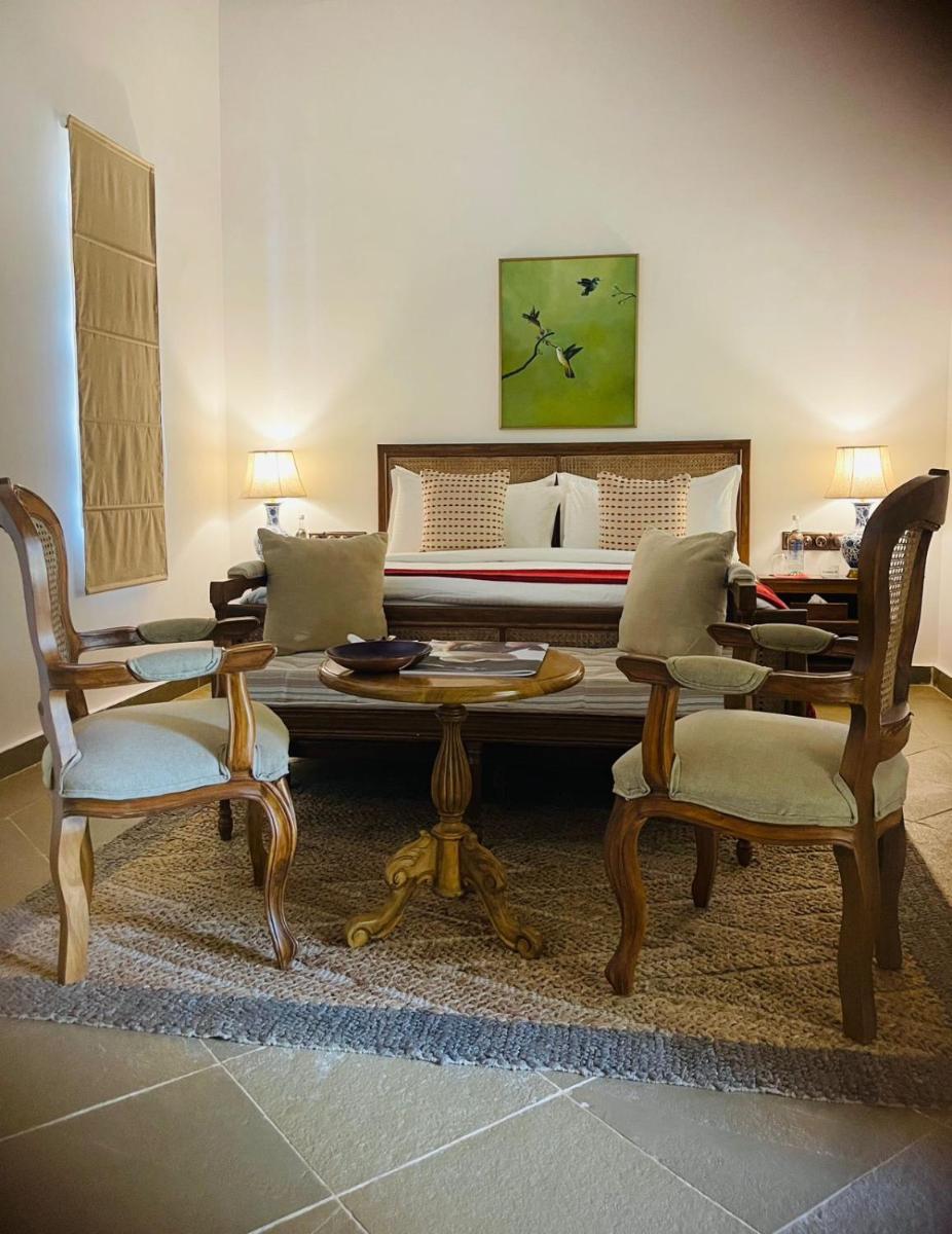 a living room with a table and chairs and a bed at The Postcard Saligao in Calangute